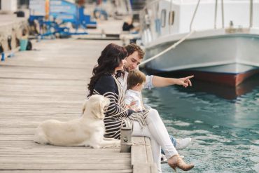 family with dog on pier