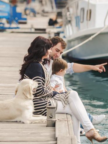 family with dog on pier