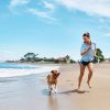Girl and dog running on beach