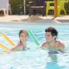 couple in pool with noodles