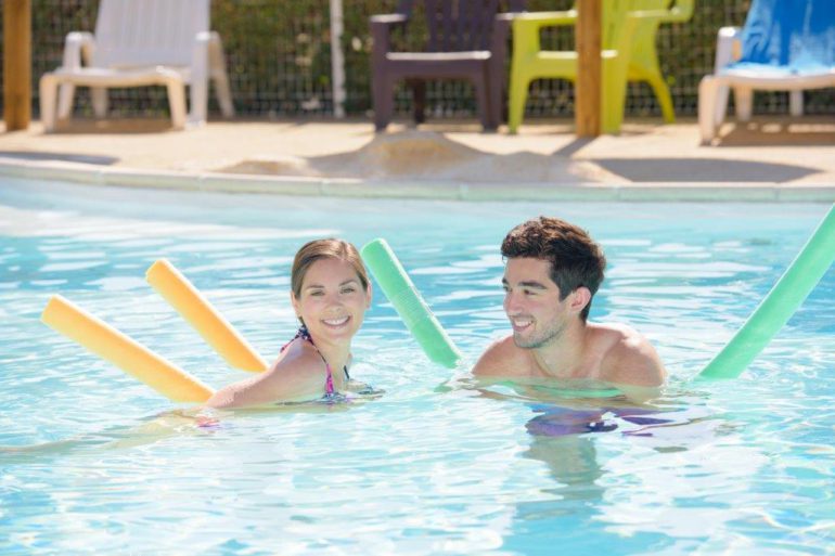 couple in pool with noodles