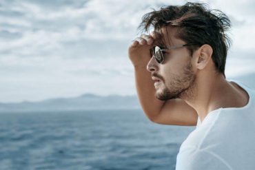guy in sunglasses looking at ocean