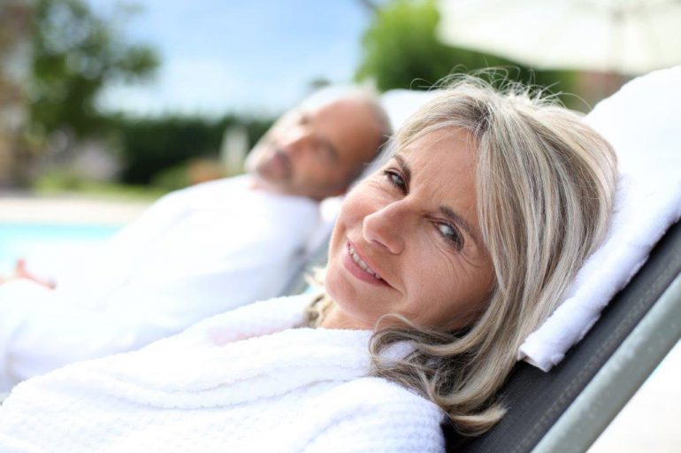 older couple relaxing by the swimming pool