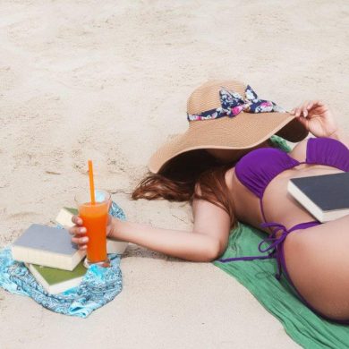 woman with books at the beach