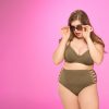 lady in plus size swimsuit pink background