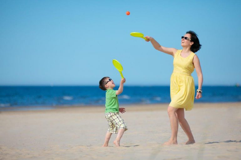 A mother and son playing on the beach