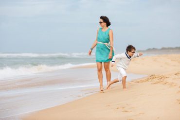 mother and son running on beach