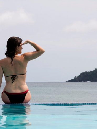 woman in pool by ocean