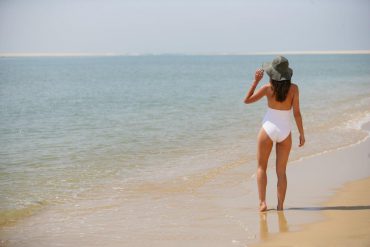 woman on shore wearing hat