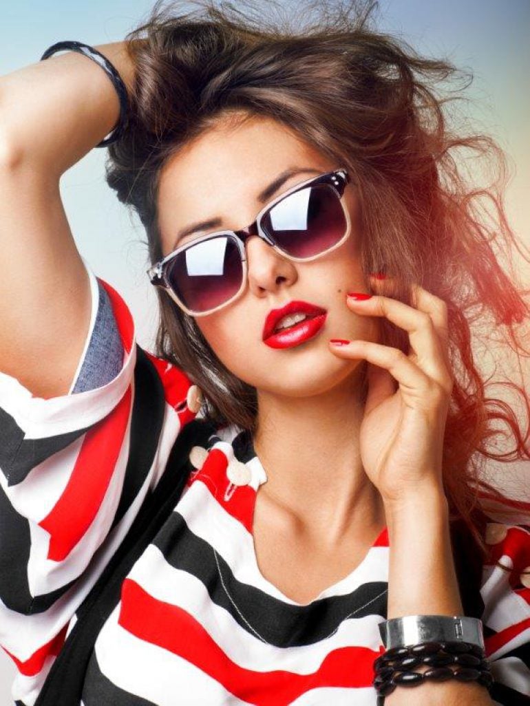 Red lips and nails compliment her red, black and white stripe top. The bracelets and shades are cool too!