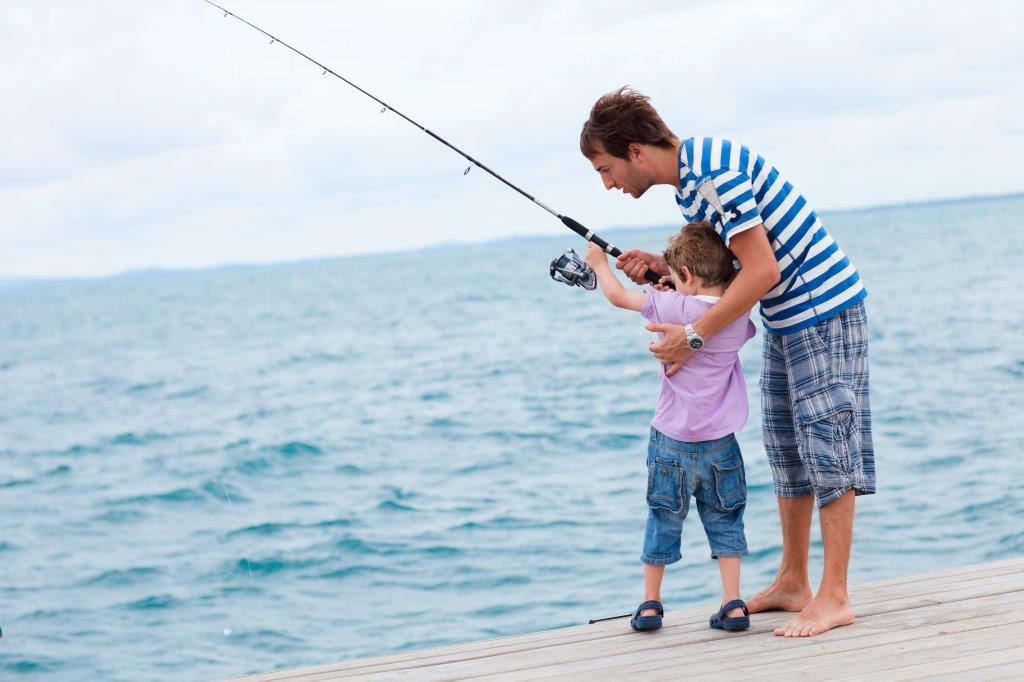 Father teaching young son to fish