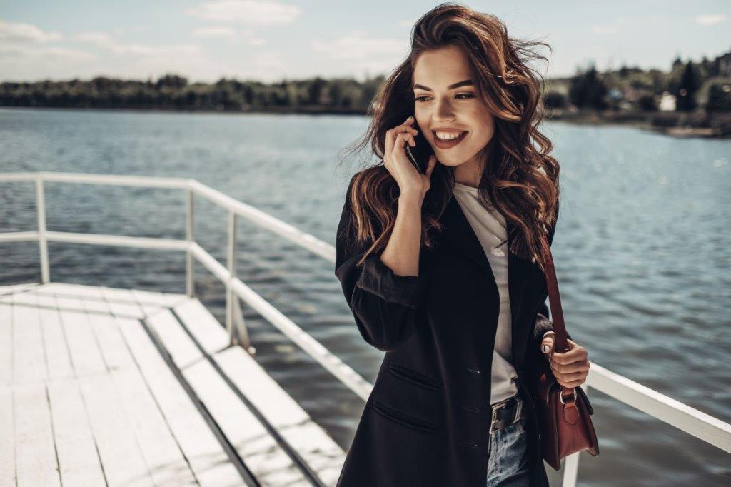 Beautiful lady in nautical fashion with white top, blue jacket and tan leather bag
