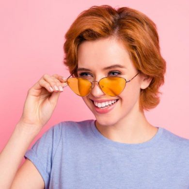 Woman wearing pink sunglasses with lenses