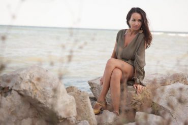 sexy woman sitting on a rock at the beach