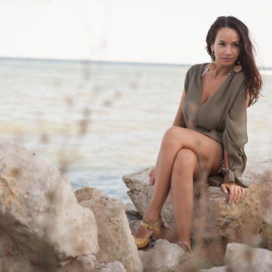 sexy woman sitting on a rock at the beach