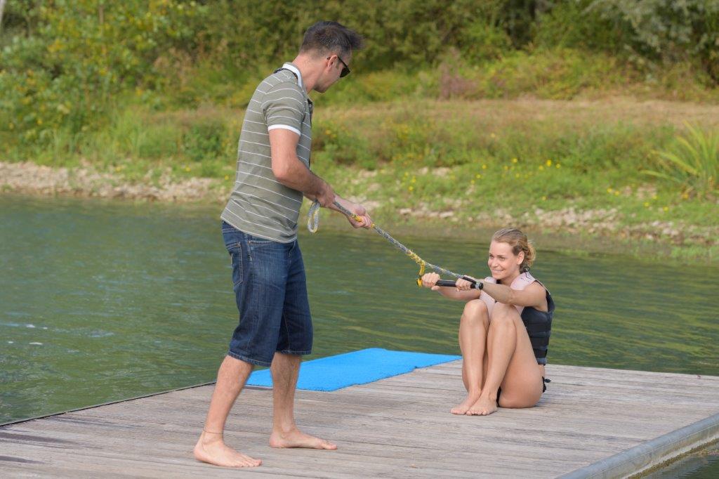 Ski instructor teaching student how to get up on skis