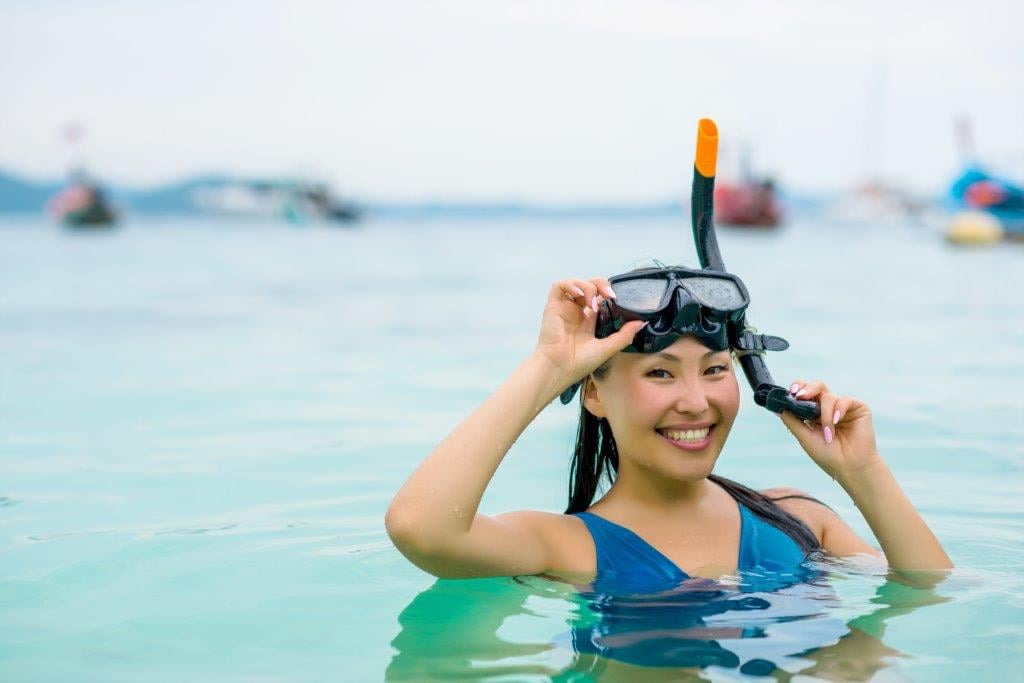 Woman coming to surface while snorkeling